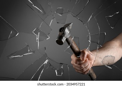 Man Breaking Window With Hammer On Dark Grey Background, Closeup