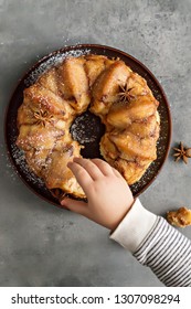 Man Breaks Off A Piece Of Monkey Bread With Cinnamon On A Wooden Table