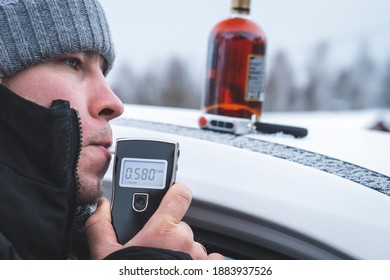 A Man With A Breathalyzer And A Bottle Of Alcohol In The Car, Testing For Alcohol And Drug Intoxication Of The Driver, Selective Focusing Tinted Image