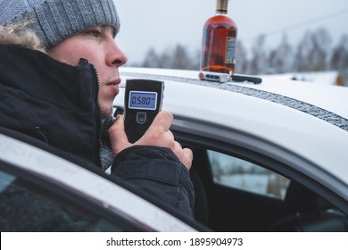 A Man With A Breathalyzer And A Bottle Of Alcohol In The Car, Testing For Alcohol And Drug Intoxication Of The Driver, Selective Focusing Tinted Image