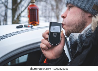 A Man With A Breathalyzer And A Bottle Of Alcohol In The Car, Testing For Alcohol And Drug Intoxication Of The Driver, Selective Focusing Tinted Image