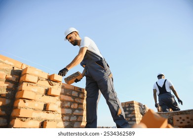 Man bricklayer installing bricks on construction site.
