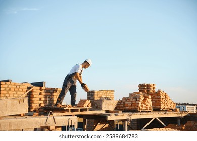 Man bricklayer installing bricks on construction site.
