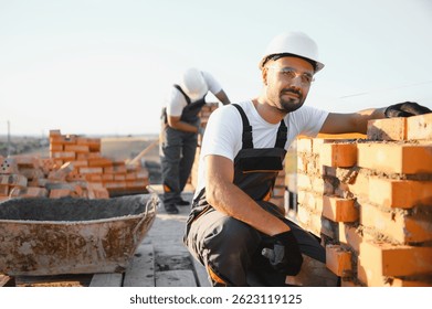 Man bricklayer installing bricks on construction site.
