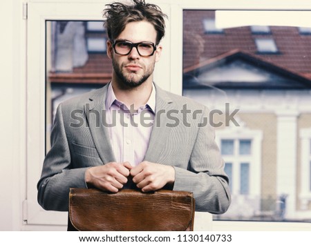 Man with briefcase isolated on white background. Nerd or brainiac wearing classic jacket. Bookworm syndrome and hard work concept. Serious teacher or worker with bristle in nerd glasses.