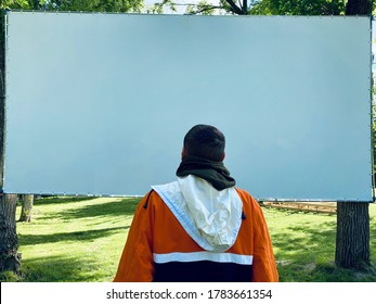 a man in bright jacket from behind looking at big white screen, copyspace