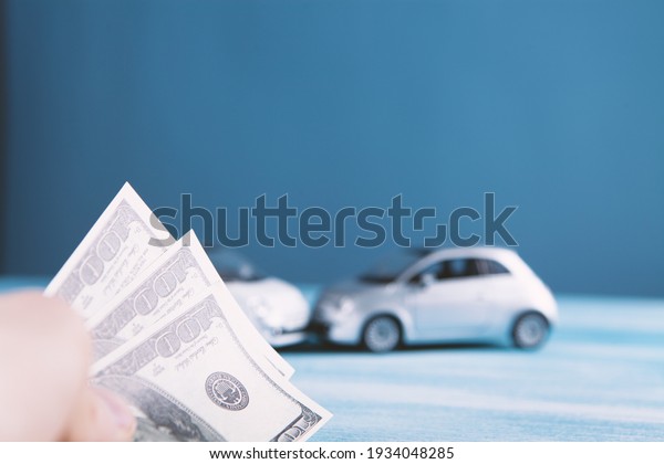 Man with broken car\
shows dollar money
