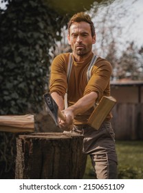 Man In Brown Clothes Is Chopping Wood With An Axe 