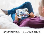 Man browsing beautiful winter photos on tablet at home