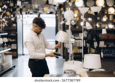 A man browsing and evaluating table lamps in a lighting store, displaying various lamp designs.