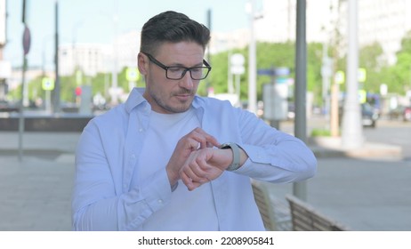 Man Browsing Internet On Smartwatch Outdoor