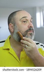 Man Is Brushing His Beard With Special Brush From Beard Grooming Kit.