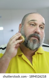 Man Is Brushing His Beard With Special Brush From Beard Grooming Kit.