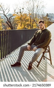 man with brutal face sitting on chair outdoors autumn sunny day copy space