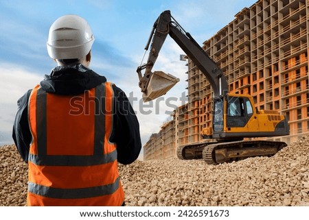 Man builder back to camera. Guy is foreman near house under construction. Architect watches work excavator. Residential area under construction near builder. Man is dressed in orange vest and hardhat