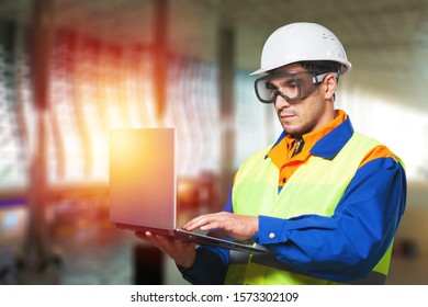 Man Builders In Hamlet Working On A Laptop With Constraction Background