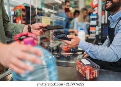 Man Buing Fresh Vegetables And Water At Grocery Store. Contactless Payment By Mobile Phone.