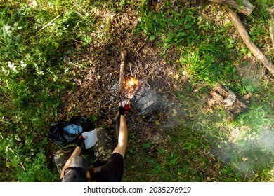 Man Burning Paper In A Campfire, Top View