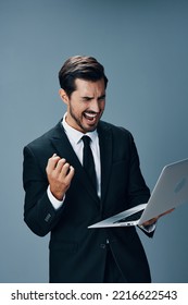 Man Business Shouting Raised Fist Up Looking At Laptop On Gray Background In Business Suit