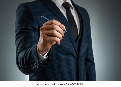 A Man In A Business Suit Holds Out His Hand With A Ballpoint Pen, Writes In The Air. Stock For Business Concept. Close-up, Copy Space