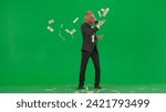 A man in a business suit with a horse head mask on a green studio background. Businessman happily scatters banknotes. Hard office work concept.