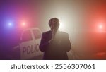 A man in a business suit is in shock on a night road, flashing police cars behind his back. Detention of a criminal concept