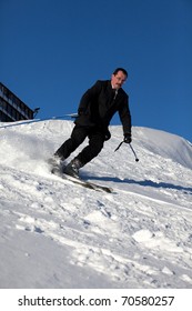 Man In Business Sute On Ski Going Down