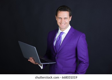 Man, Businessman Or Manager Smiling With Laptop Or Computer On Black Background. Technology For Business. Formal Violet Suit And Dress Code. Internet Surfing