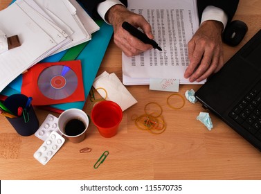 Man At Busy, Untidy Desk