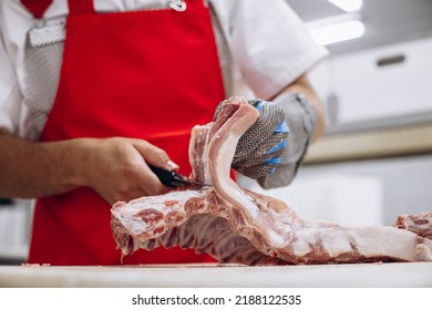 Man Butcher At The Freezer Cutting Meat