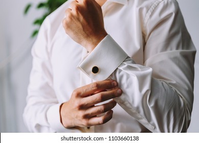 The man buttoned a white shirt. There is a darker clip on the cuffs. Wedding. - Powered by Shutterstock