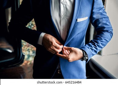 A Man Buttoning A Blue Jacket