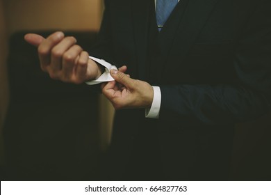 Man Buttoning Suit Cuff