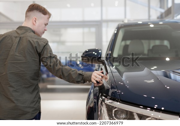 man buys a car dealership. signing a trade-in\
contract and handing over keys, shaking hands. A successful man\
chooses a new car. Service center for rental or repair of vehicles.\
trade in loan secured