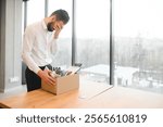 Man by dismissal. Guy lost job. Fired manager in company. Dismissal box in hands of employee. Man office worker disappointed by dismissal. Fired male in blurred office. Discharge company employees