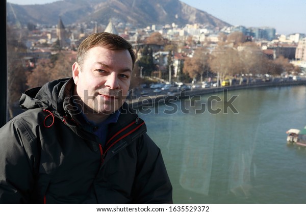 Man in cabin of\
cable car, Tbilisi, Georgia