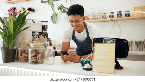 Man, cafe and barista with smile at phone for ecommerce, networking and communication at counter. Male person, small business and waiter with technology for online sale, funny discussion and service - Powered by Shutterstock