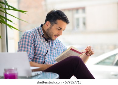 Man in caffe restaurant reading book - Shutterstock ID 579357715