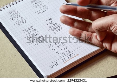 Man calculating and checking the monthly expenses by hand. Selective focus.