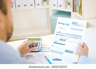 Man Calculating Electric Bill Statement And Home Energy Consumption