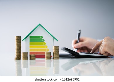 Man Calculating Invoice With Energy Efficient Chart And House - Shutterstock ID 1612695901