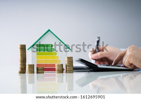 Man Calculating Invoice With Energy Efficient Chart And House