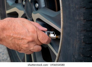 Man calibrating car tire - closeup on hand