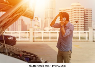 A Man Calling For Assistance With His Car Broken Down By The Parking Lot