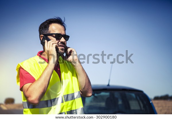 Man calling to insurance company by phone\
after a car breakdown.