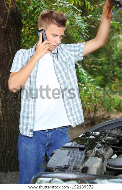Man calling\
repair service after car\
breakdown