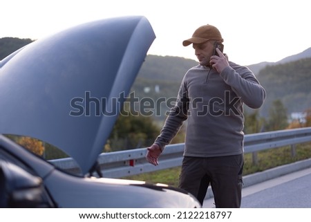 Man calling towing service for help on the road. Roadside assistance concept