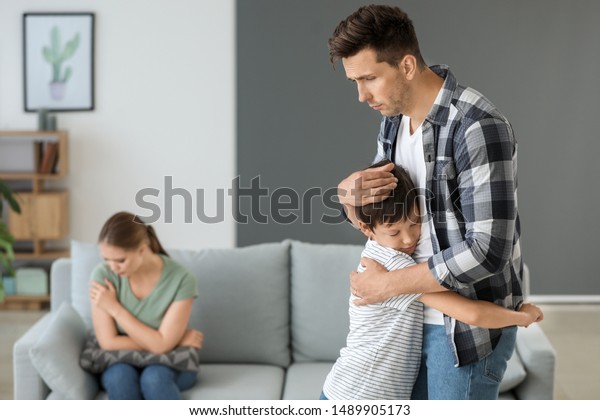 Man calming
his son after family quarrel at
home