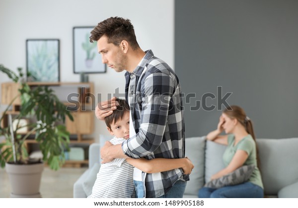 Man calming
his son after family quarrel at
home