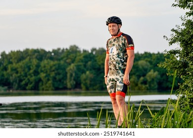 A man in a camo shirt and helmet stands on a dock overlooking a body of water. The scene is peaceful and serene, with the man looking out over the water and taking in the view - Powered by Shutterstock